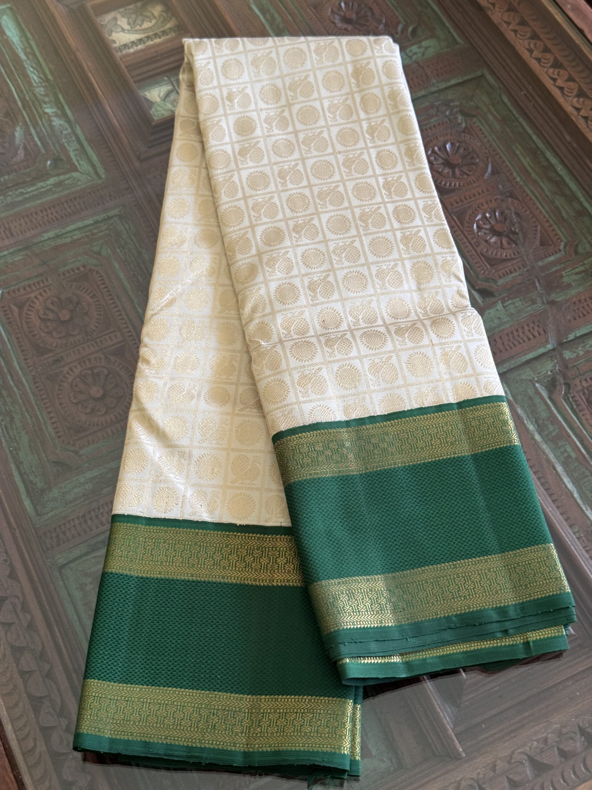 Sanghavi ivory silk saree with emerald green 3g pure gold zari border.