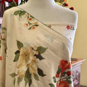 Tia cream Chanderi Mul saree with orange floral prints and triangular tassels.