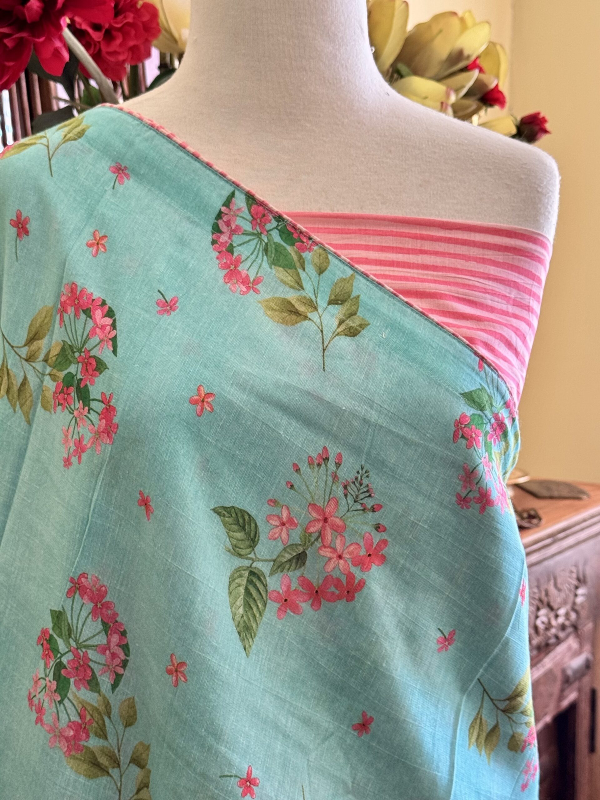 Zoya sky blue Chanderi silk saree with pink floral prints and striped tulip tassels.