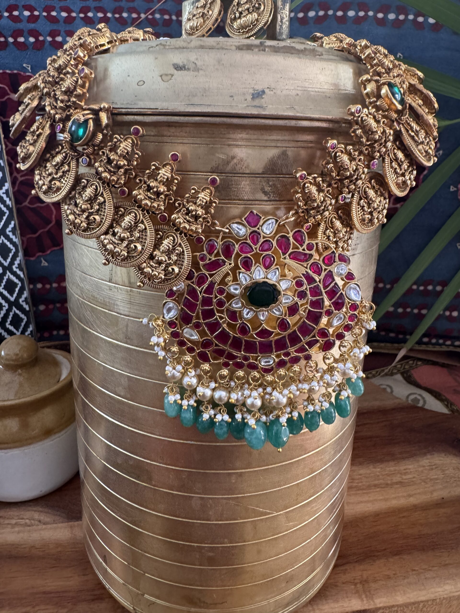 Traditional gold-toned Lakshmi coin necklace with a Jadau Kundan pendant and matching earrings.