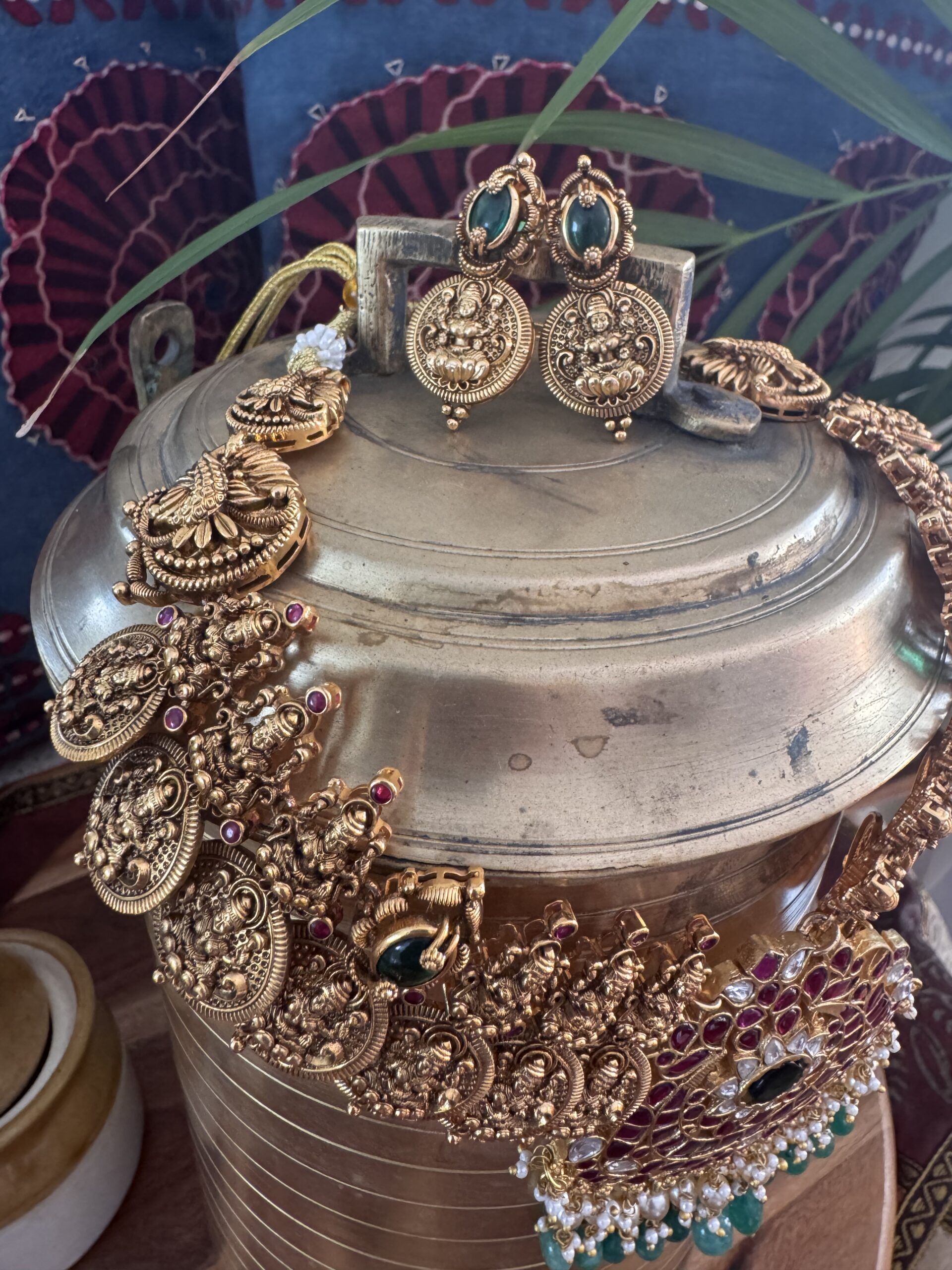 Traditional gold-toned Lakshmi coin necklace with a Jadau Kundan pendant and matching earrings.