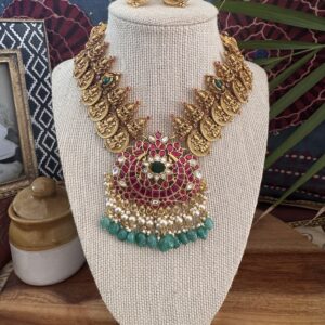 Traditional gold-toned Lakshmi coin necklace with a Jadau Kundan pendant and matching earrings.