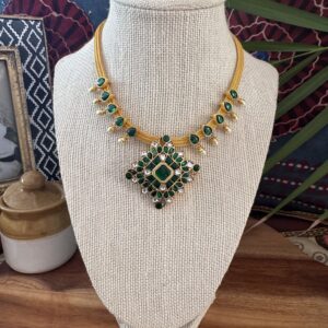 Green Jadau Kundan necklace on a gold cord.