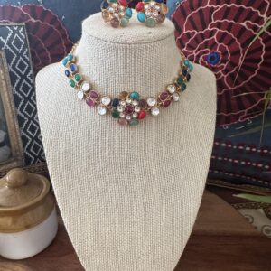 Gold-toned Jadau choker with pink, blue, and green stones and matching floral earrings.