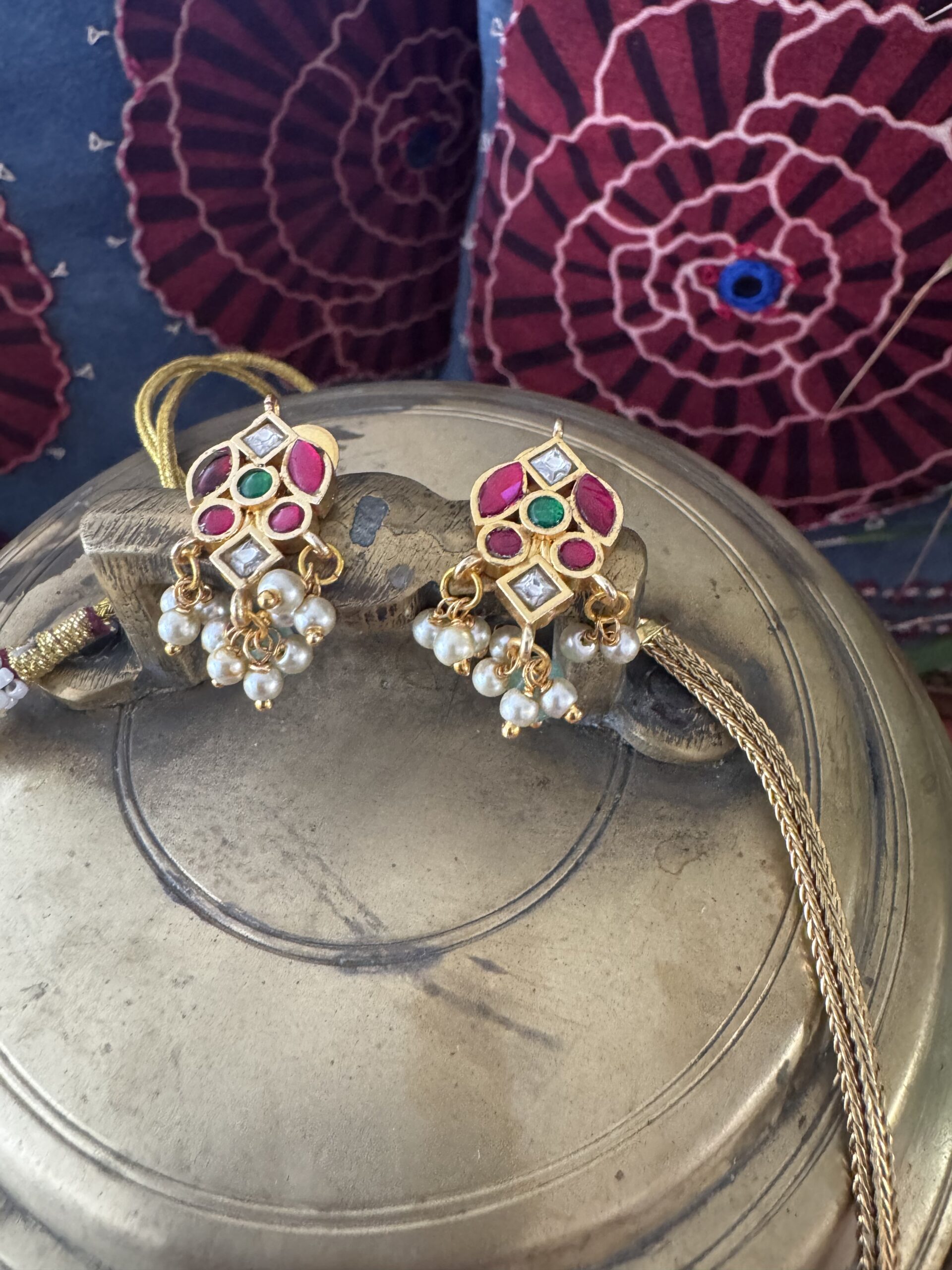 Gold-toned necklace with a pink and green Kundan pendant and pearl drops.