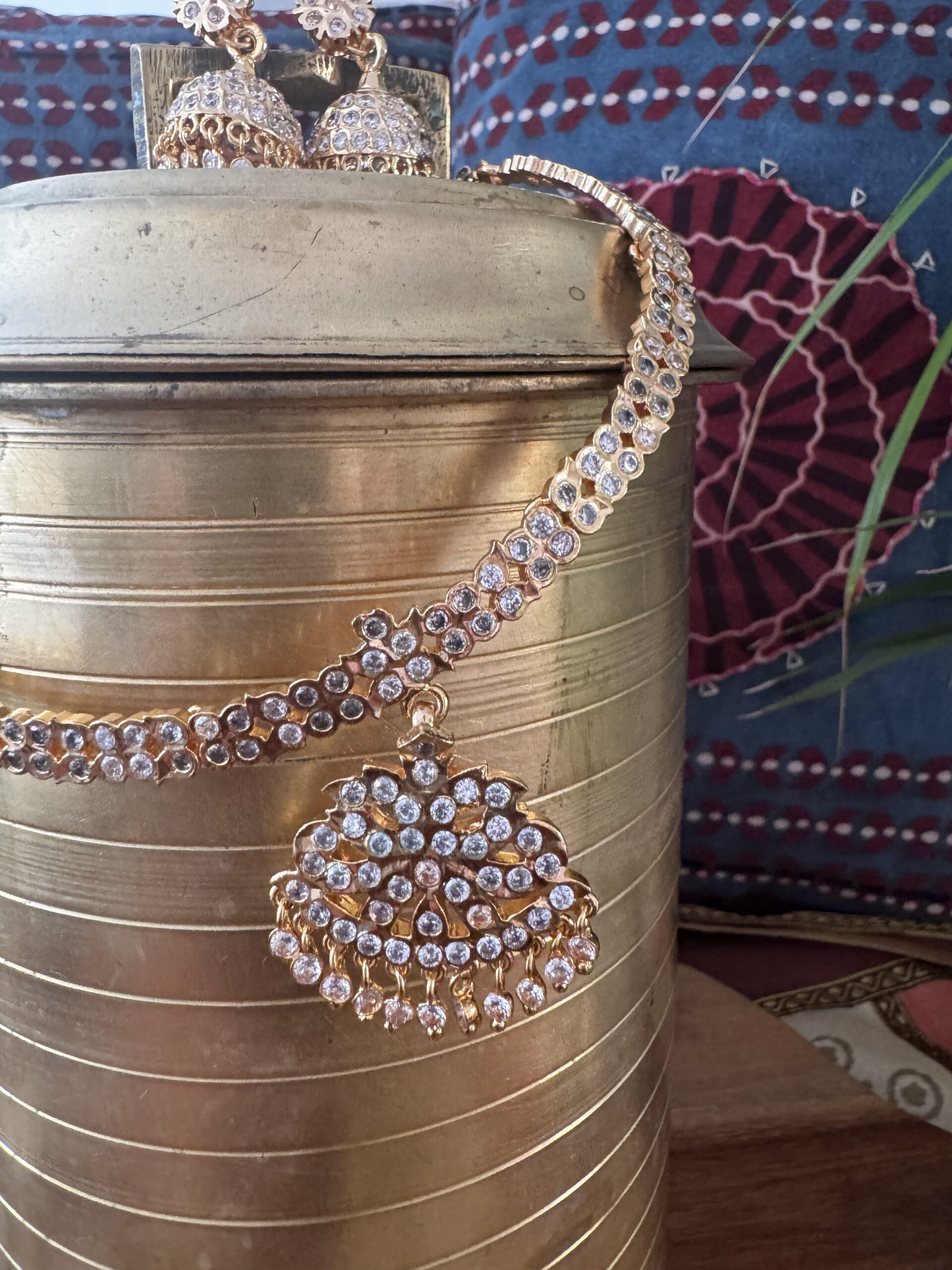 Gold-toned necklace with a pink and green Kundan pendant and pearl drops.