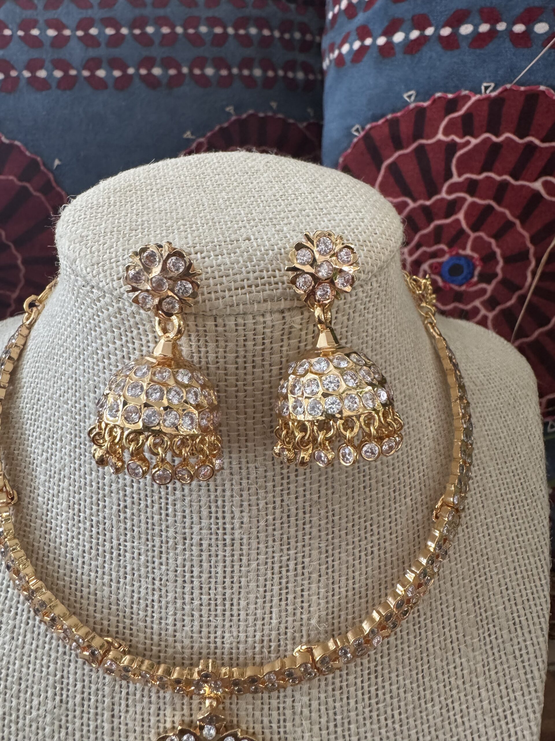 Gold-toned necklace with a pink and green Kundan pendant and pearl drops.