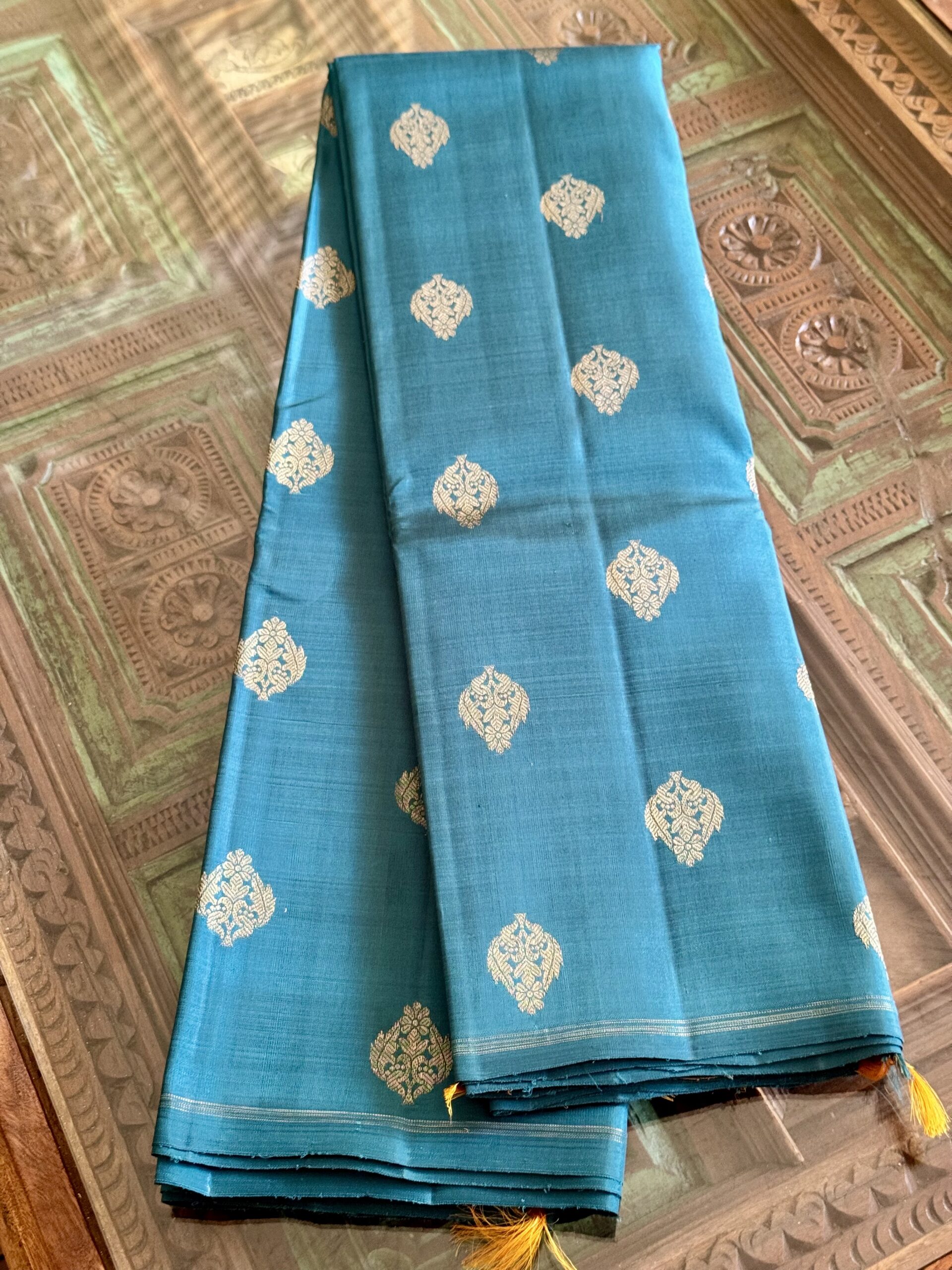 Hamsini teal blue pure Kanjivaram silk saree with all-over zari motifs and a golden yellow 3g zari pallu.