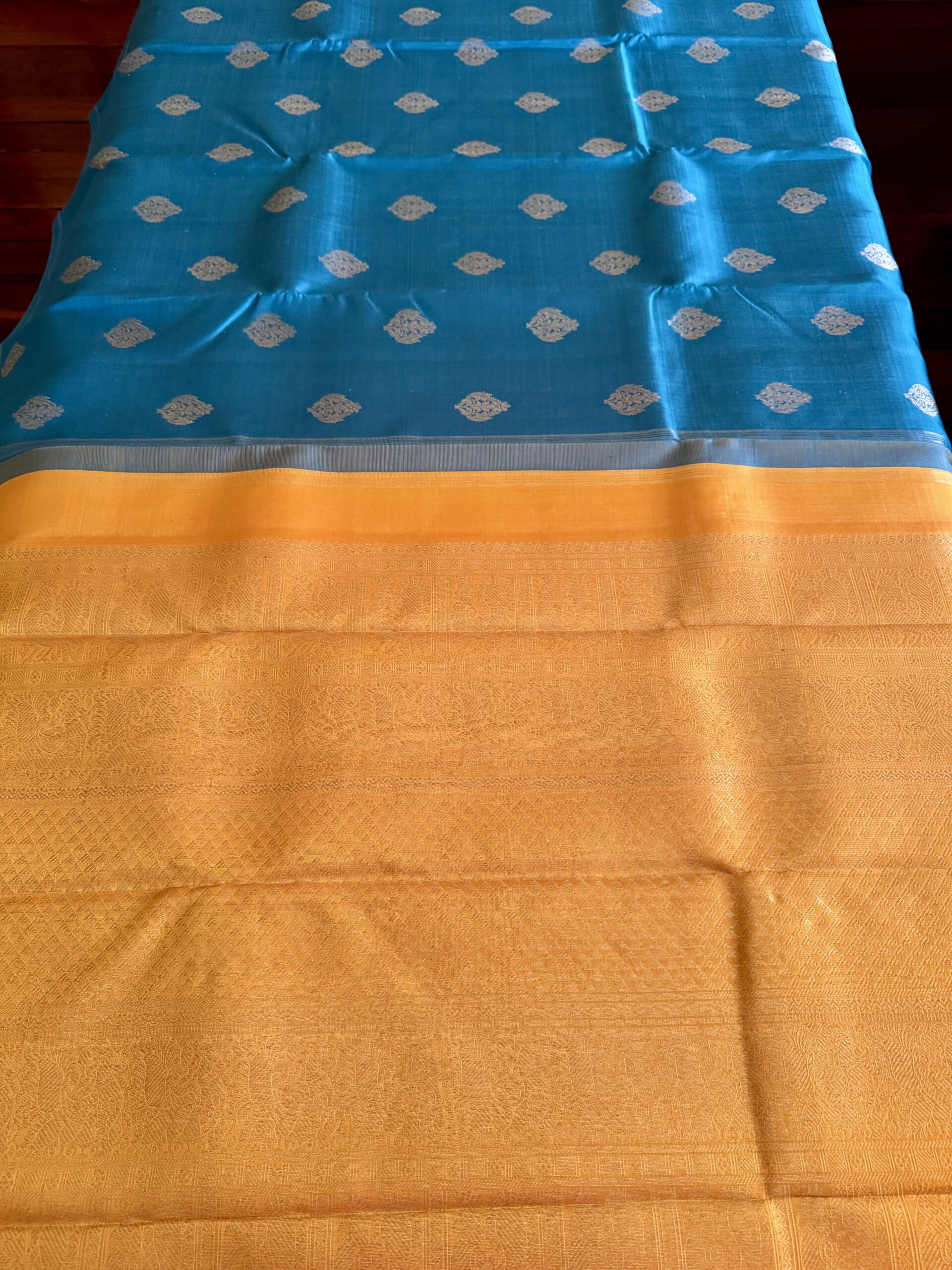 Hamsini teal blue pure Kanjivaram silk saree with all-over zari motifs and a golden yellow 3g zari pallu.