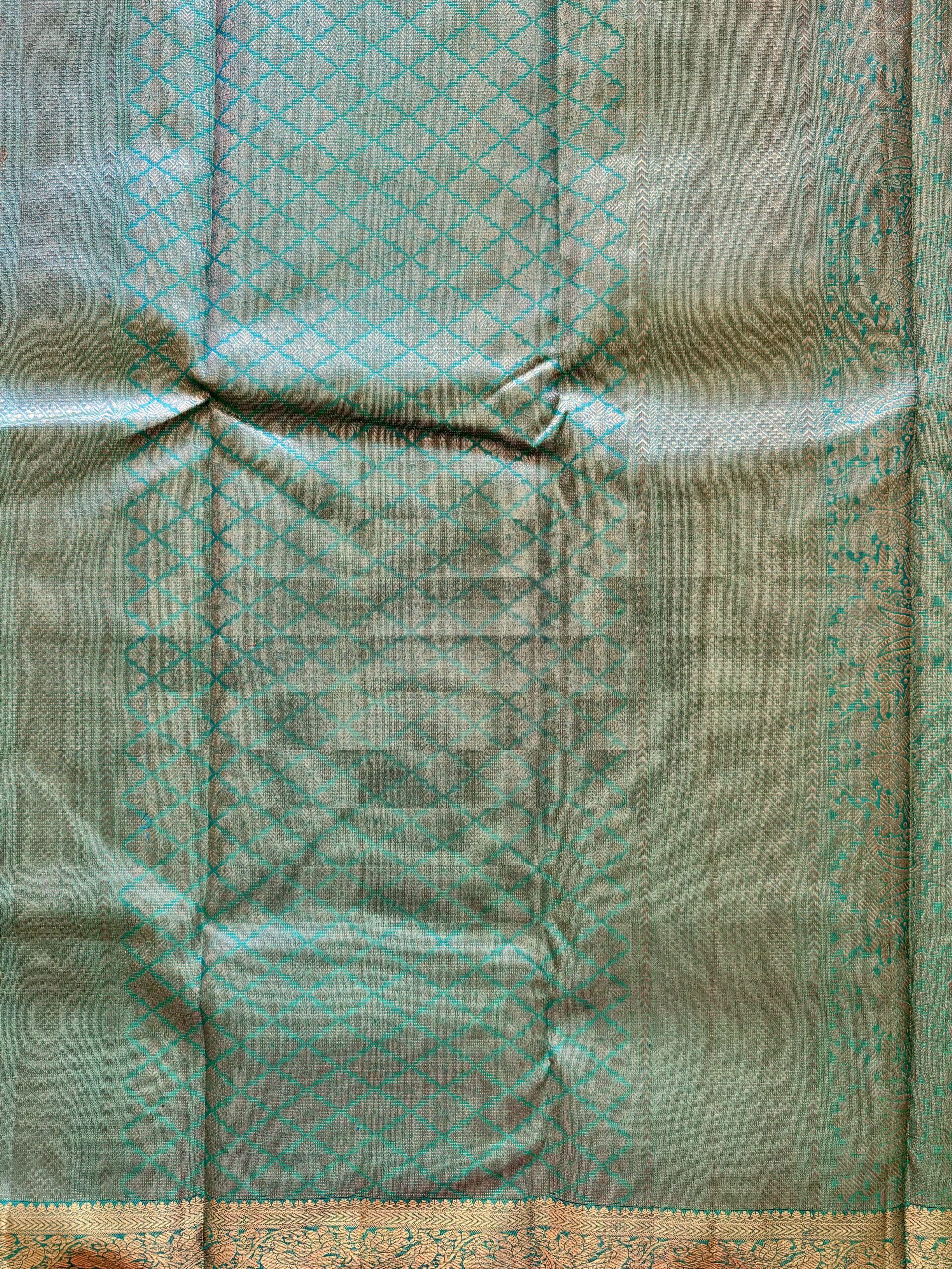 Iniya turquoise blue-green shot Kanjivaram silk saree with zari buttas and uneven Annam borders.
