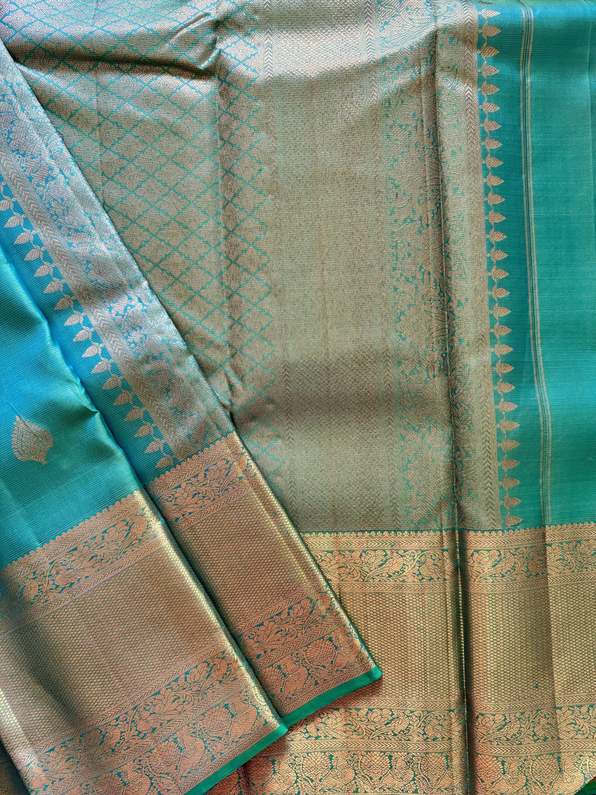 Iniya turquoise blue-green shot Kanjivaram silk saree with zari buttas and uneven Annam borders.