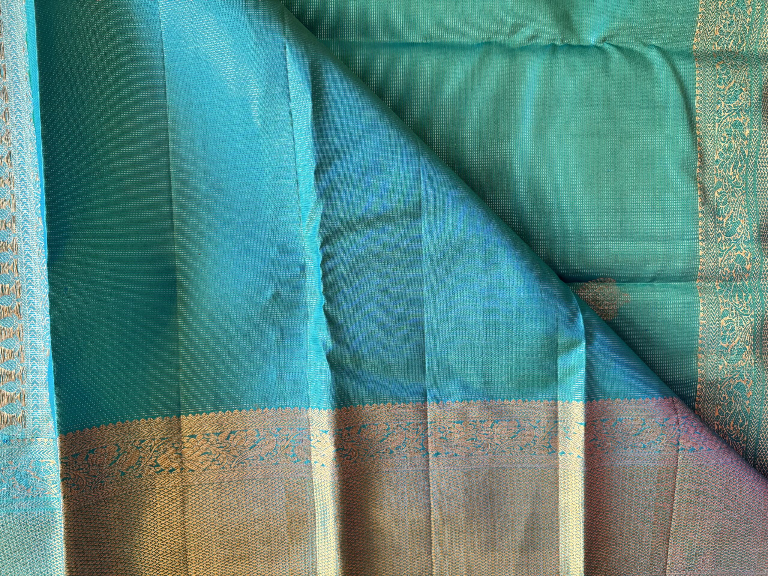 Iniya turquoise blue-green shot Kanjivaram silk saree with zari buttas and uneven Annam borders.