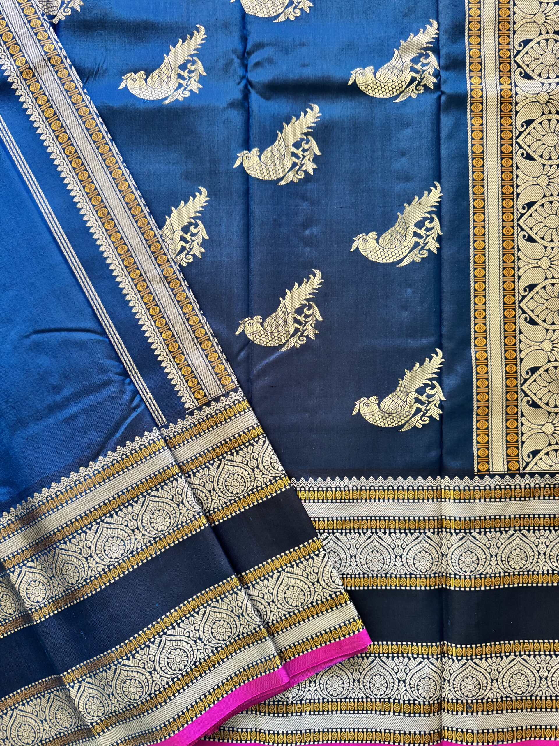 Meera dark blue shot Kanjivaram silk saree with asymmetrical threadwork borders and magenta selvage.