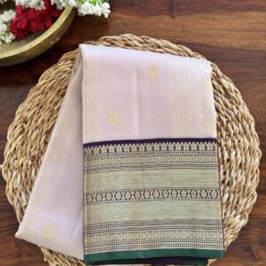 Tia beige mauve shot Kanjivaram silk saree with dark purple zari border and green selvage.