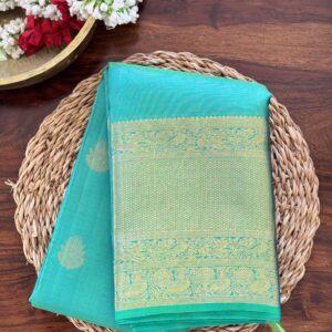 Iniya turquoise blue-green shot Kanjivaram silk saree with zari buttas and uneven Annam borders.