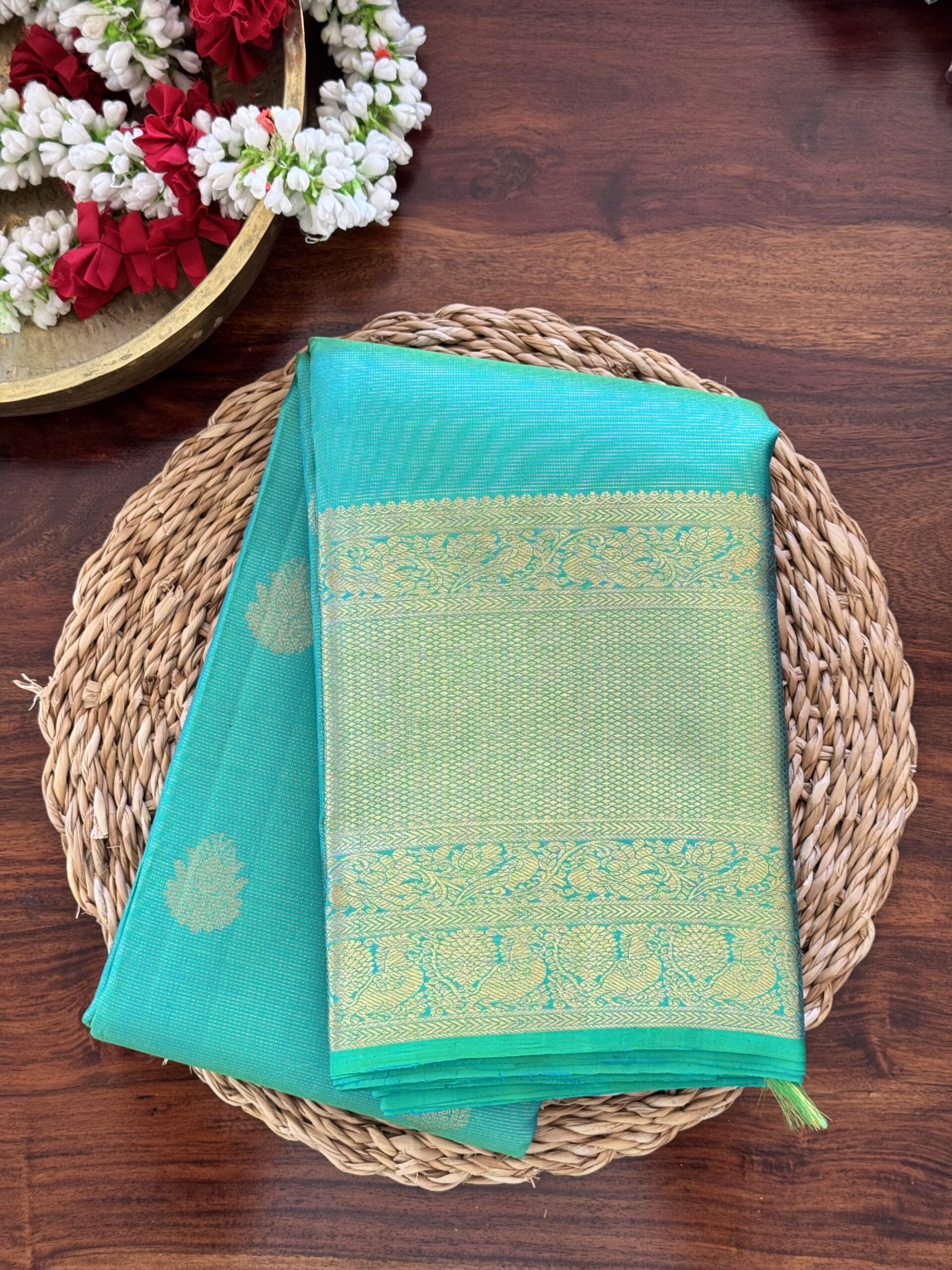 Iniya turquoise blue-green shot Kanjivaram silk saree with zari buttas and uneven Annam borders.