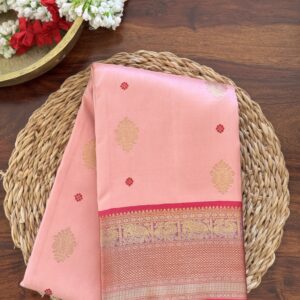 Nyra soft peach pink pure Kanjivaram silk saree with magenta border and zari motifs.