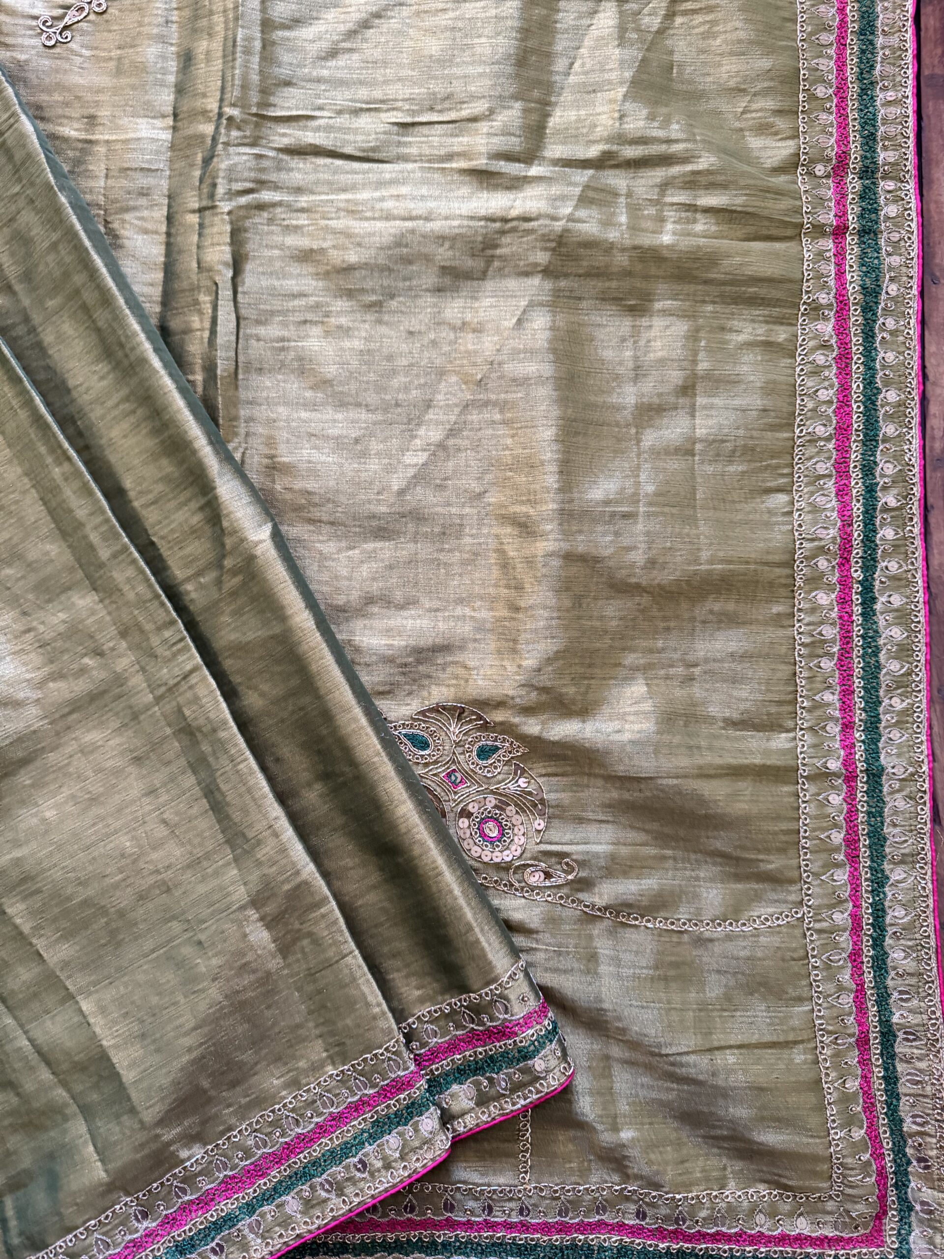 Close-up of hand-embroidered peacock pallu motif on Suvarna gold tissue silk saree — gold zari, emerald green thread, pink sequin and mirror work by Tari by Gayatri