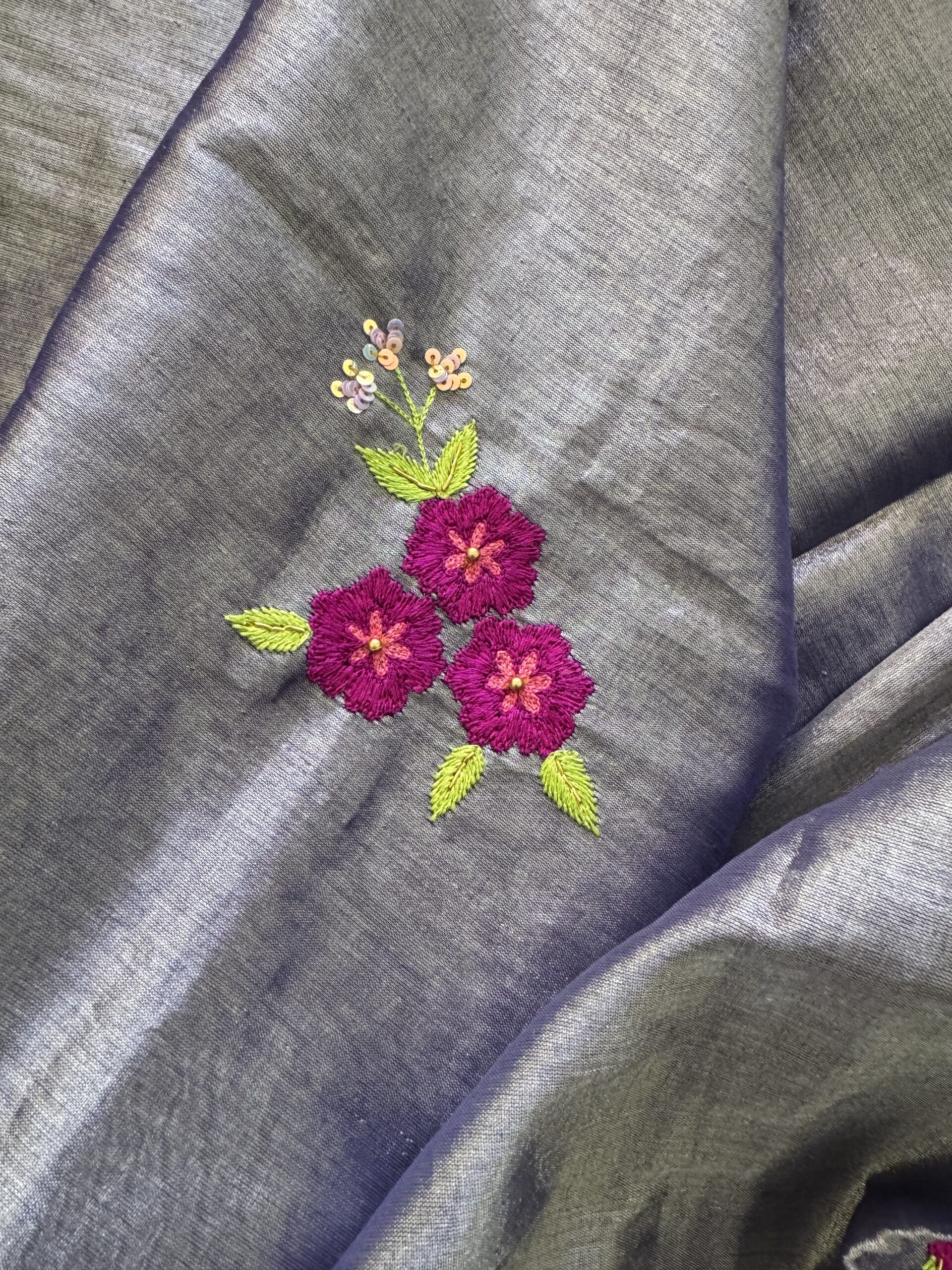 Close-up of hand-embroidered magenta three-bloom floral cluster with lime green leaves and peach filler buds on Shubhra silver tissue silk saree — Tari by Gayatri