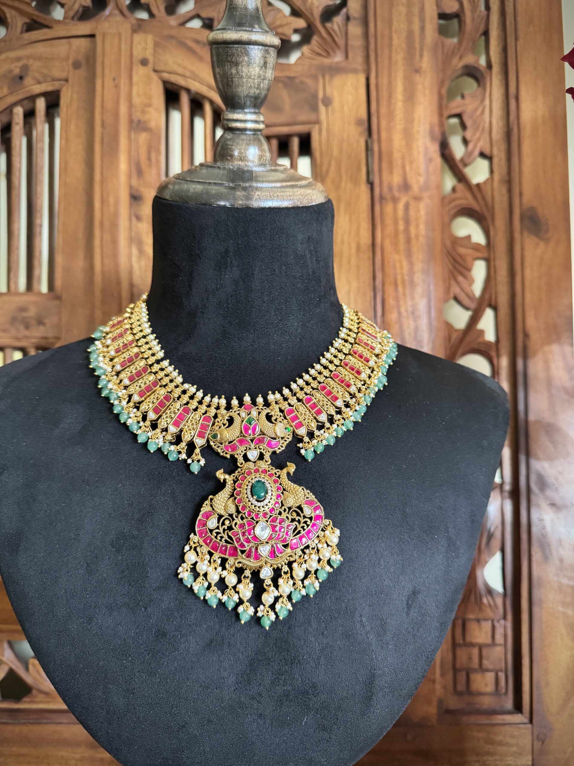 IBIT traditional temple necklace with a large peacock pendant and matching pink jhumki earrings with green bead drops