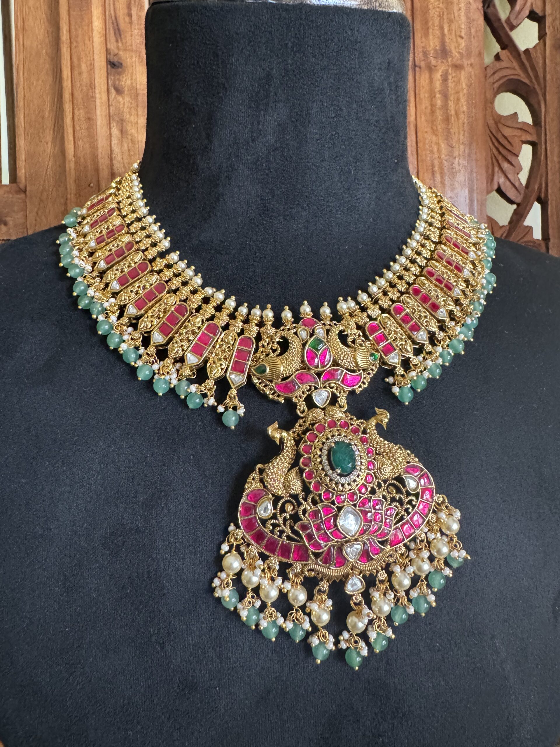 IBIT traditional temple necklace with a large peacock pendant and matching pink jhumki earrings with green bead drops