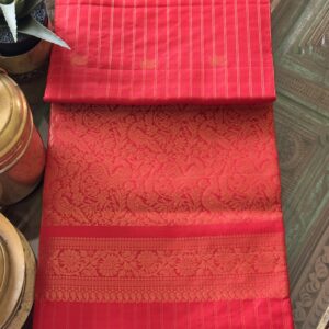 Nandini tomato red soft silk saree with gold zari checks and a peacock pallu with tassels.
