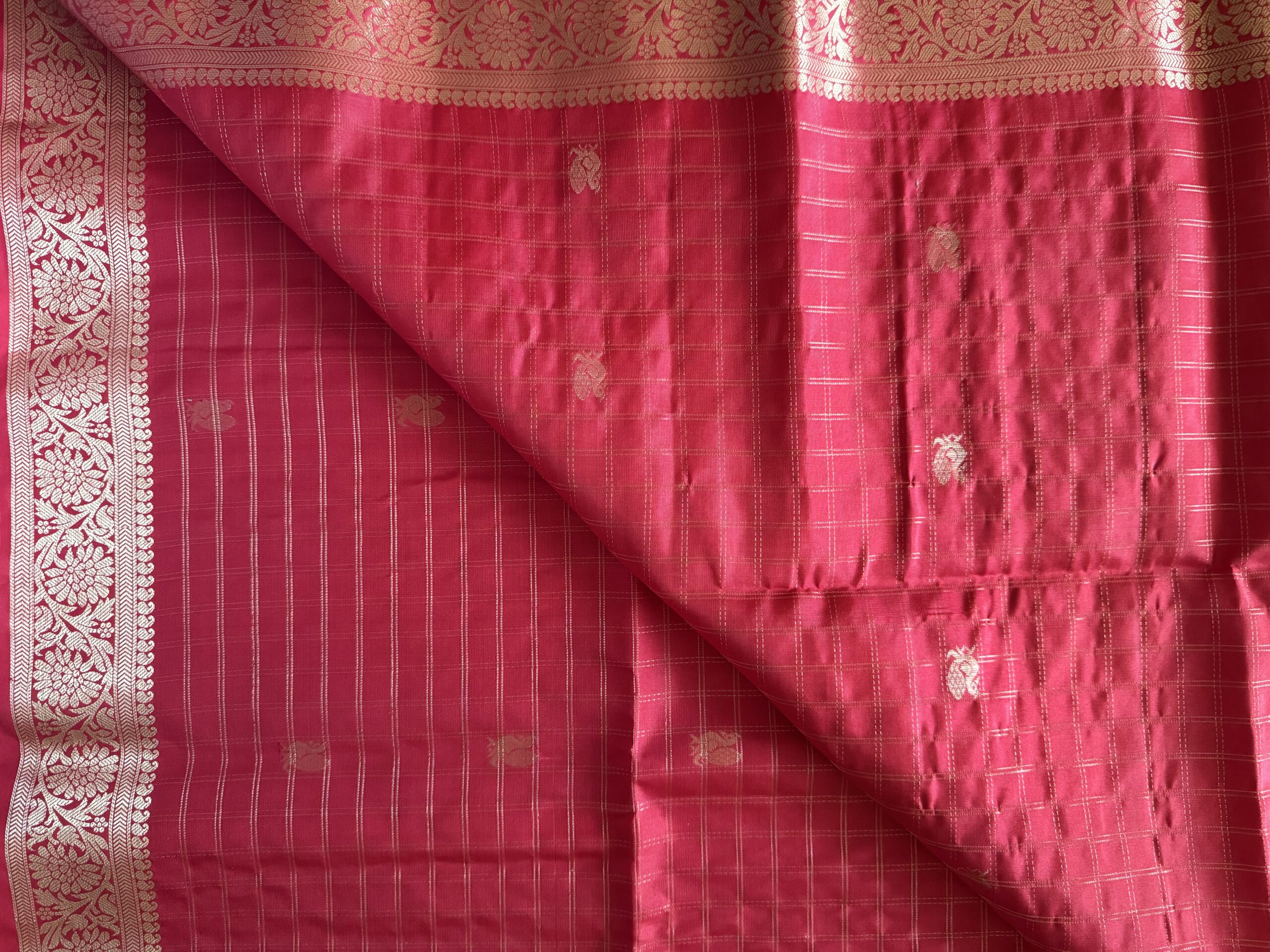 Nandini tomato red soft silk saree with gold zari checks and a peacock pallu with tassels.