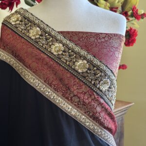 Nisha jet black georgette saree with a maroon and gold embroidered border and a Banarasi blouse piece.